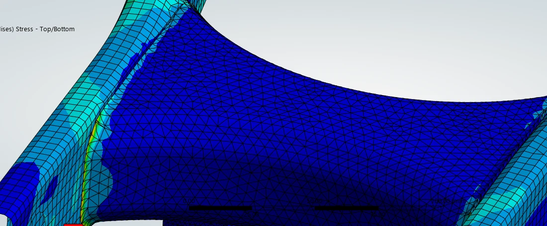 Stress plot showing the solid crossmember lightly loaded next to highly stressed arm walls.